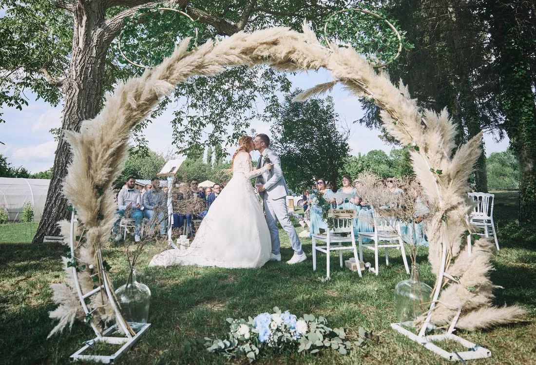 Baiser sous une arche de fleurs séchées
