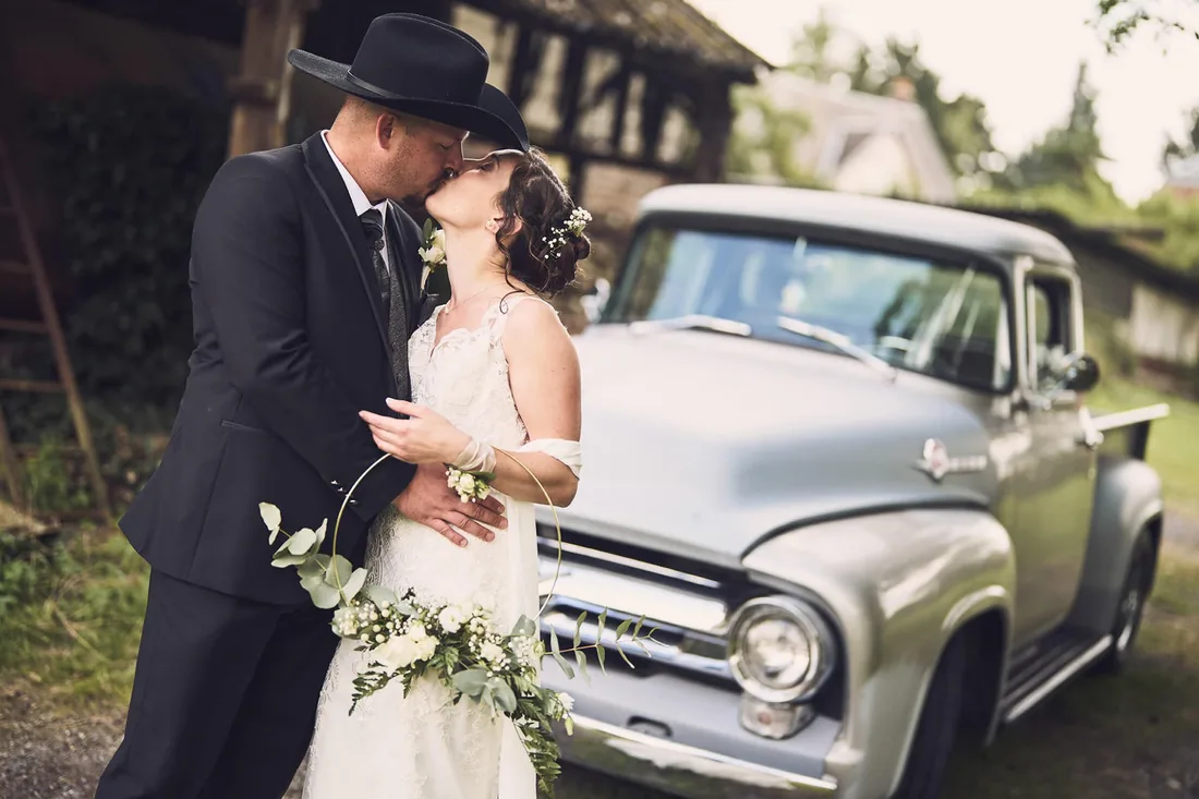 Baiser devant un pick-up ancien, décor champêtre