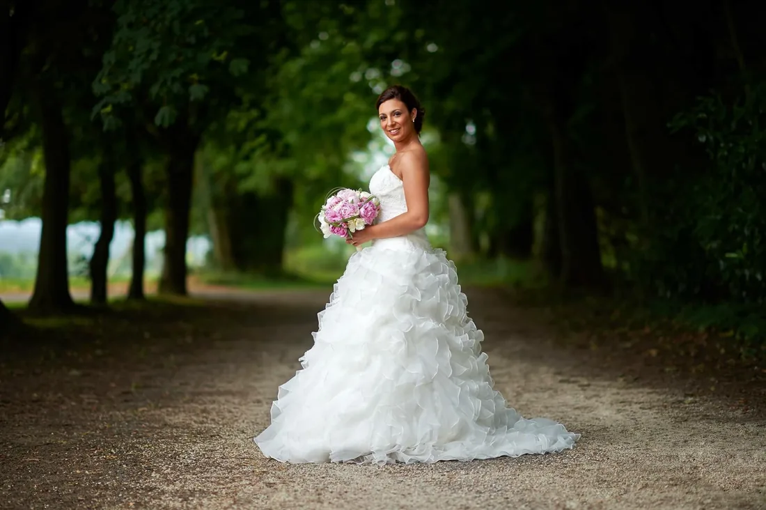 Portrait de la mariée sous une allée d'arbres