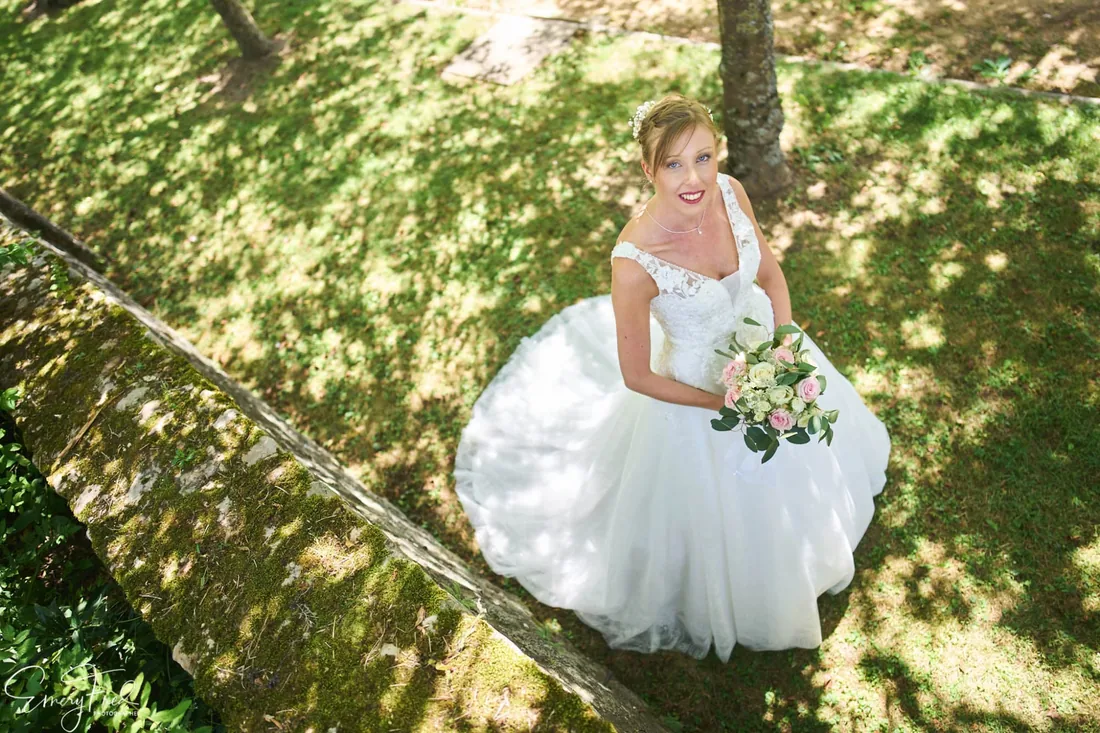 Portrait de la mariée en contre-plongée, jardin ombragé
