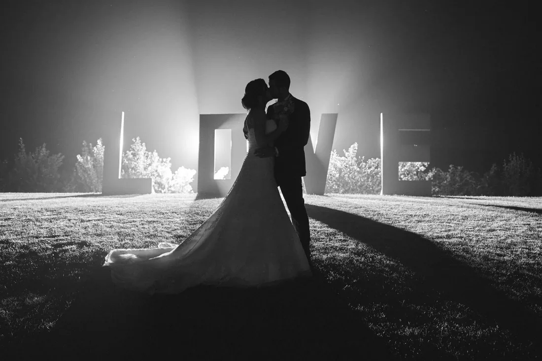 Silhouette sous les lettres lumineuses « LOVE »